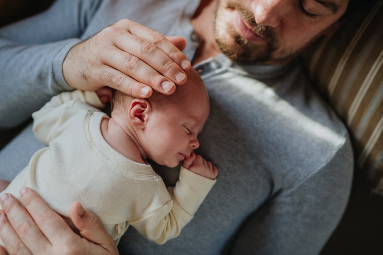 Father holding sleeping newborn